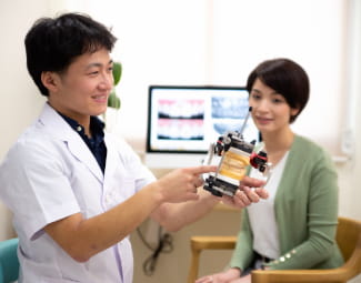 歯列模型を持つ男性